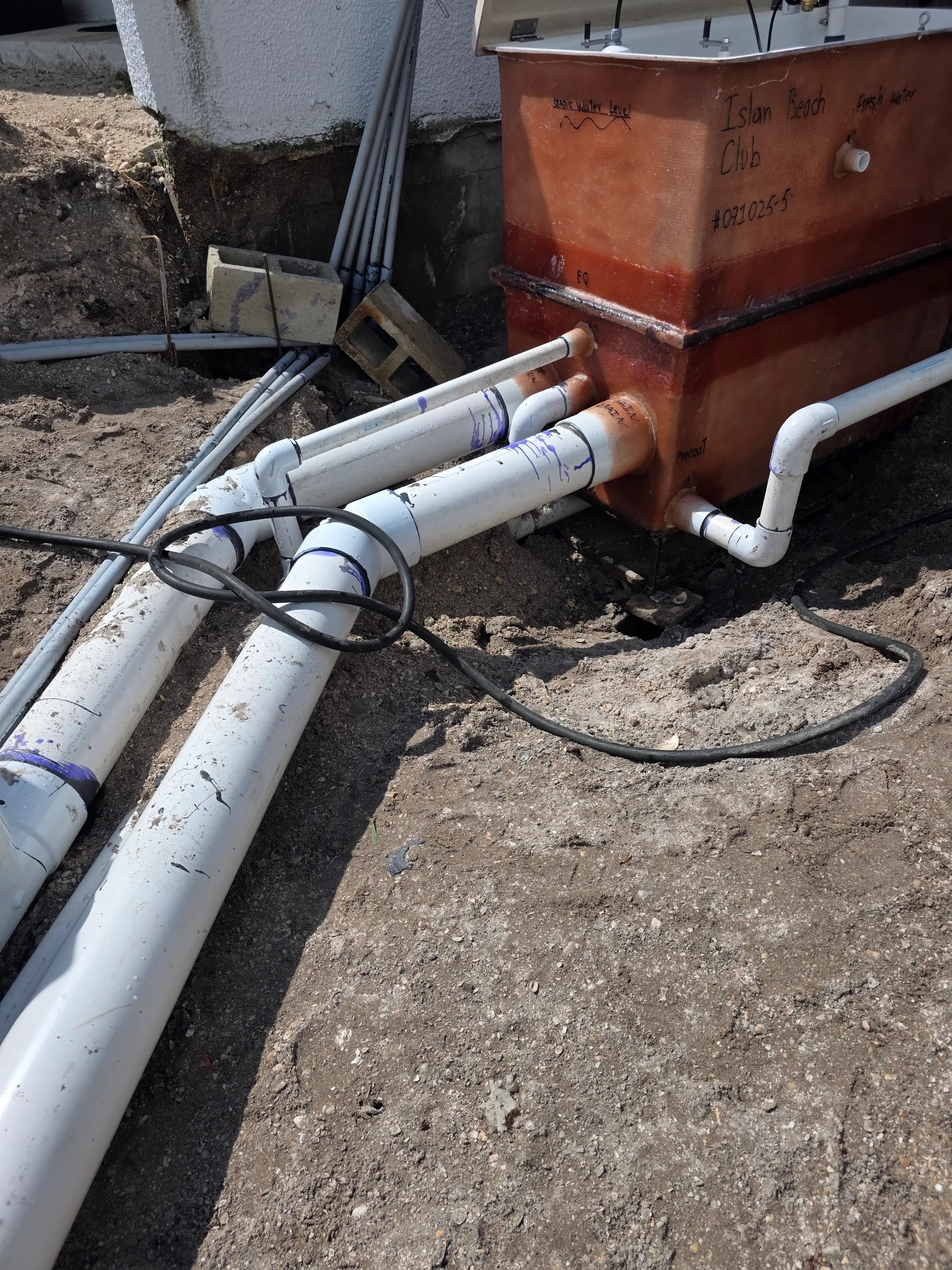 PVC pool plumbing lines connected to copper equipment manifold with valves and fittings