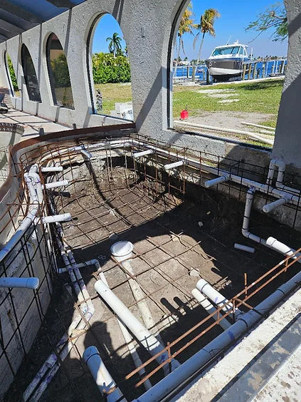 Interior vessel demolition showing exposed steel framework and cleared hull with porthole windows